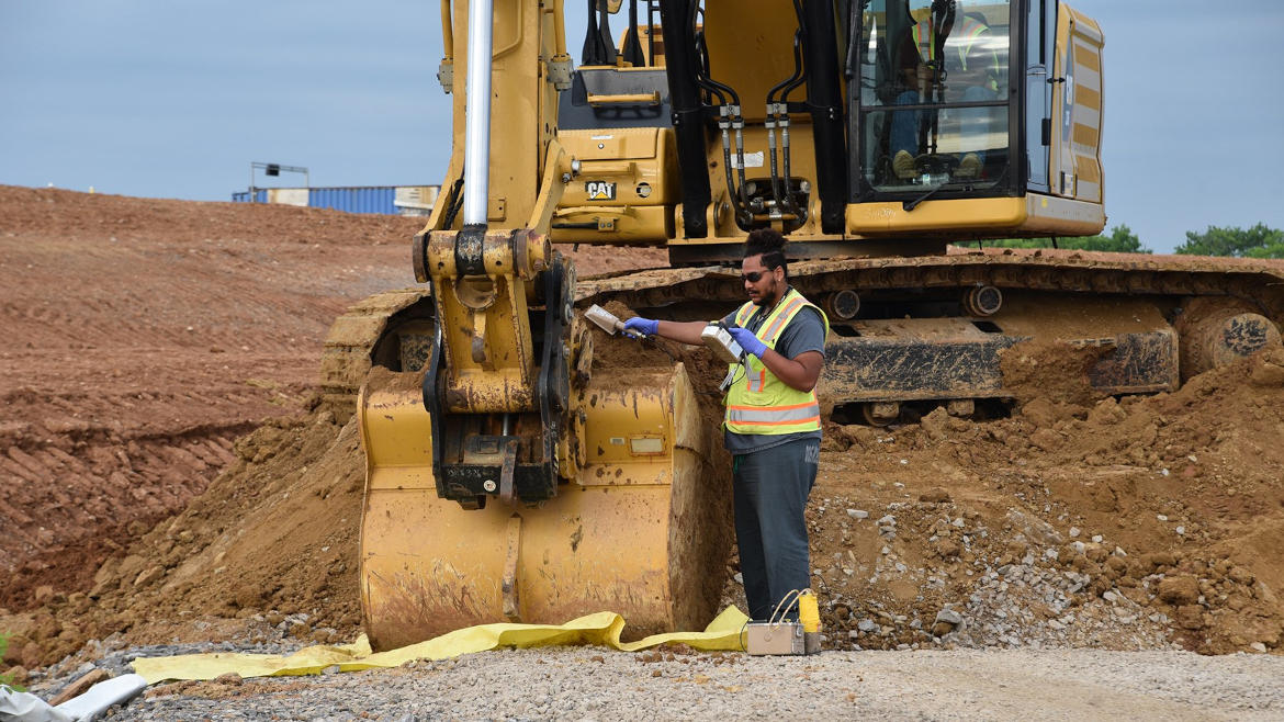 worker scans excavated soil